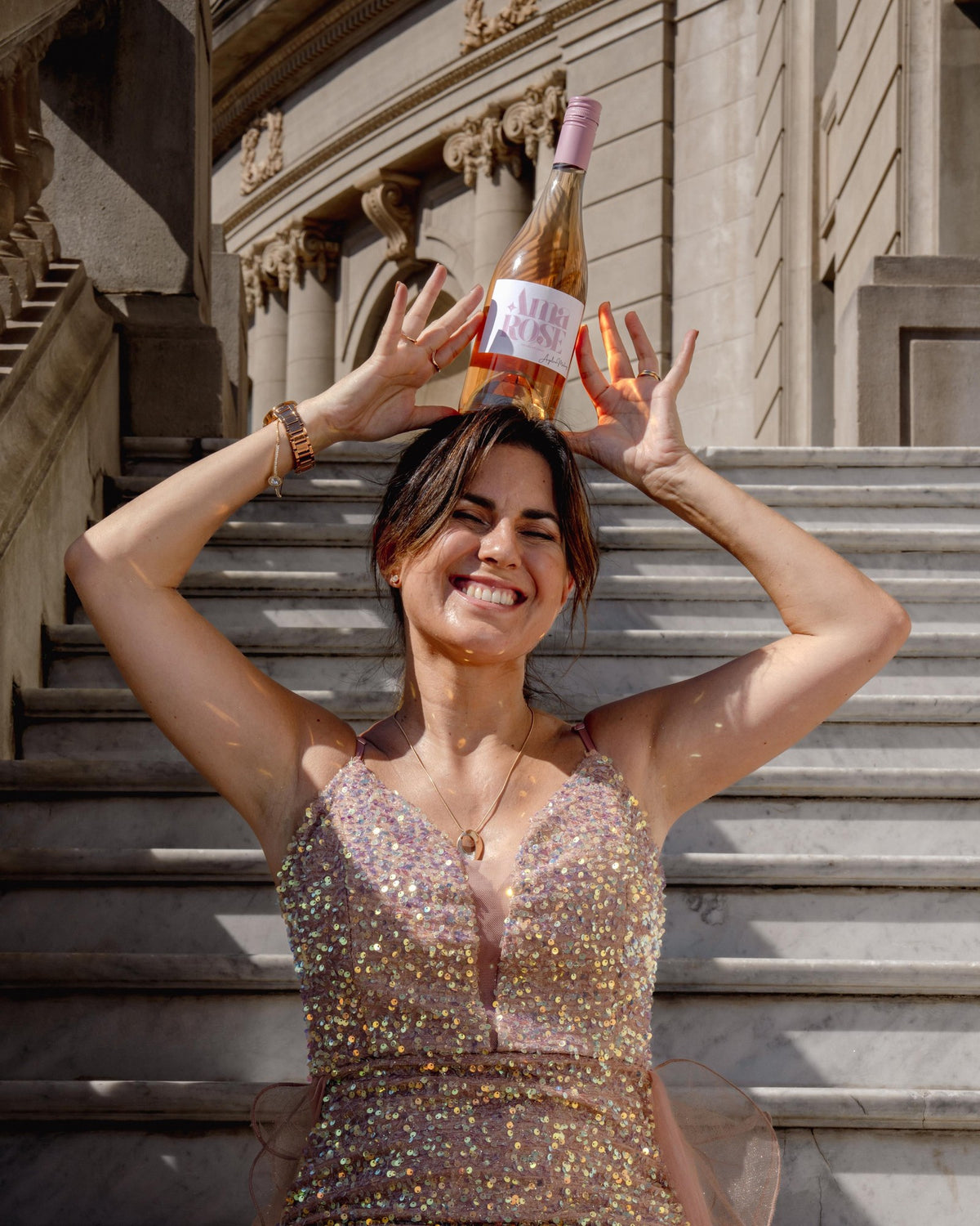 Angelina Martínez riendo con una botella de Ama Rose sobre la cabeza